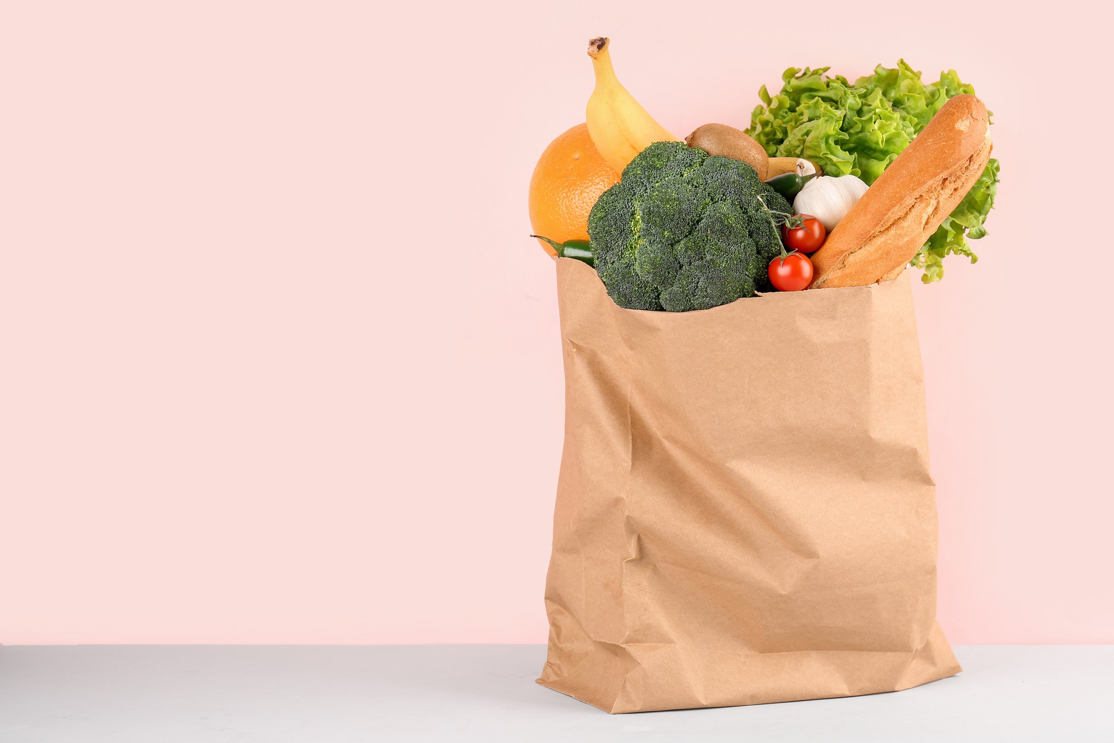 Paper Bag with Vegetables and Fruits on Pink Background